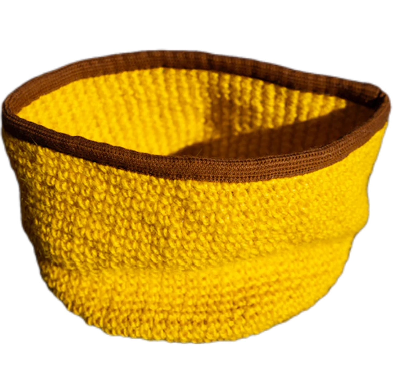 Cesto porta giochi per gatto di Orme Differenti, lavorato a uncinetto in fibre 100% naturali, colore giallo e bordo di cotone marrone rinforzato.