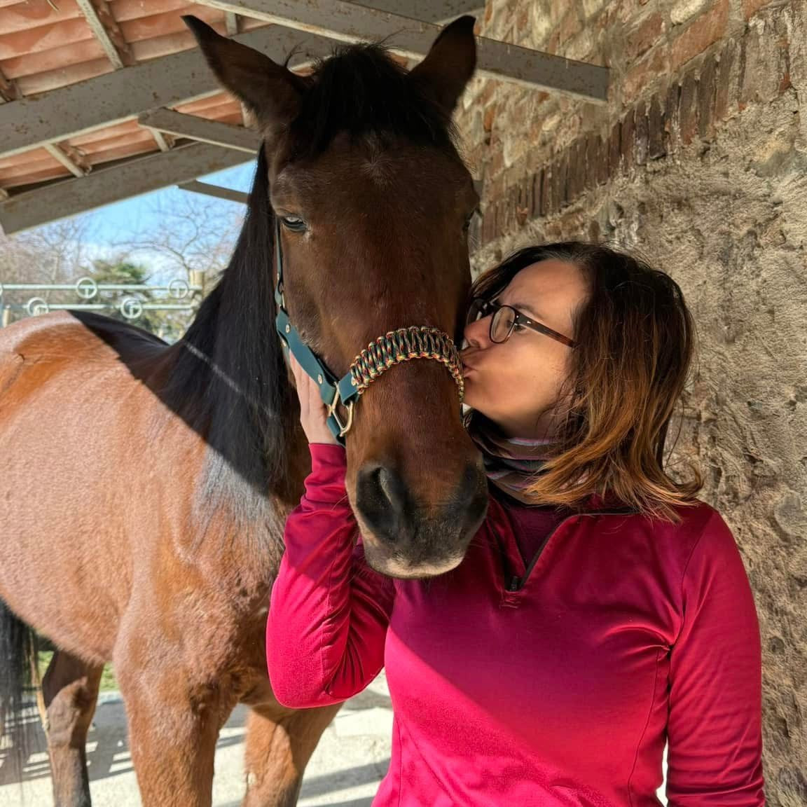 consulenza di aromaterapia per animali, donna che bacia cavallo baio, orme differenti